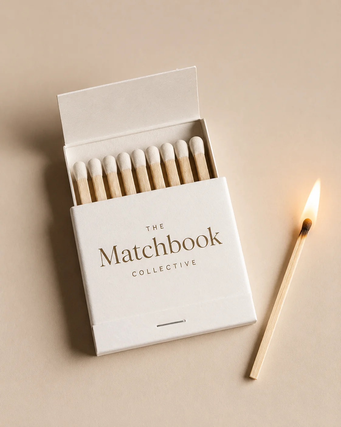 An open Matchbook Collective matchbook and a single burning match.